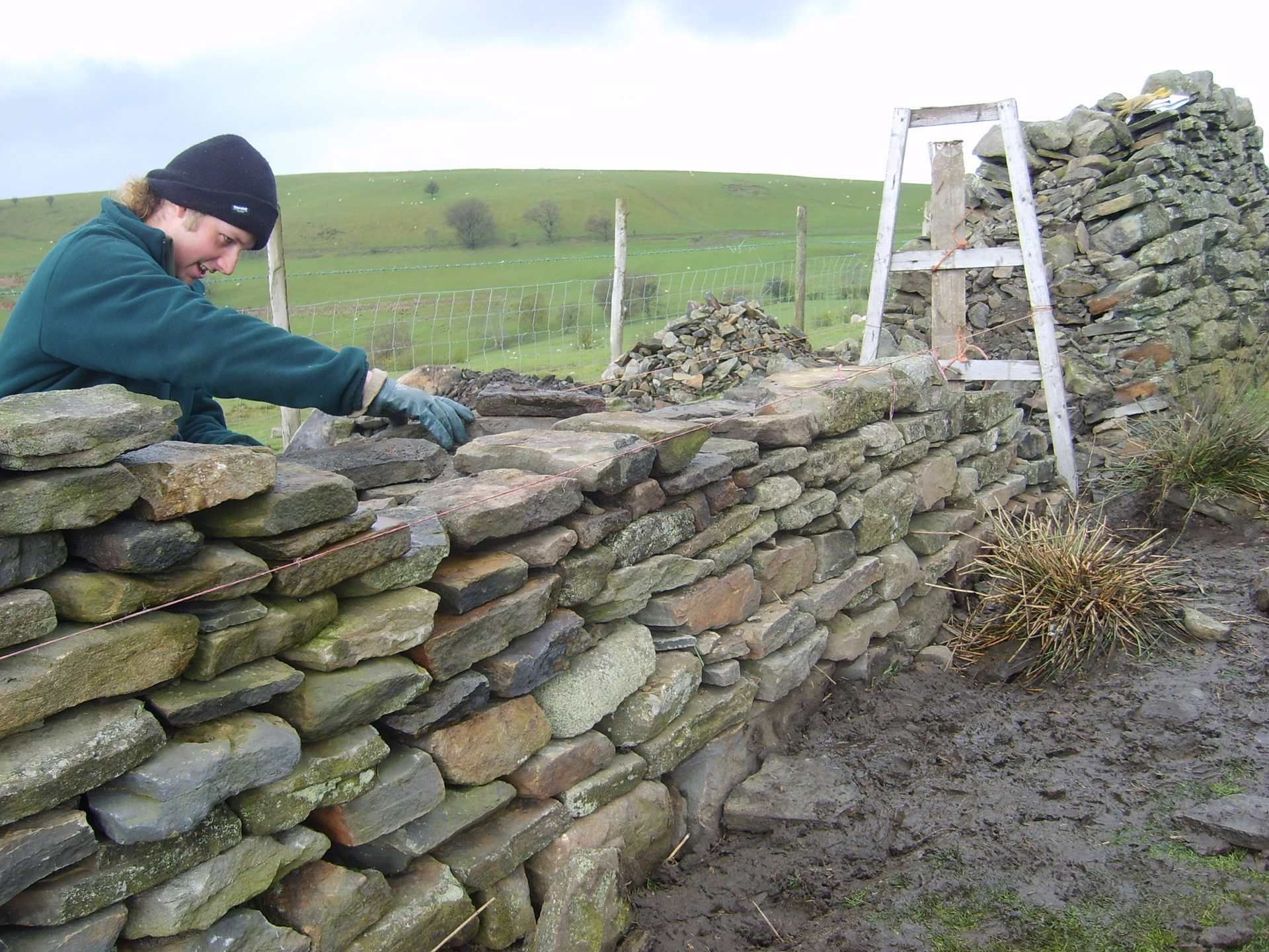 Mason building a dry stone wall by hand